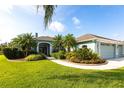 Well-maintained home featuring a beautifully landscaped front yard, mature trees, and a three-car garage at 9017 Province St, Sarasota, FL 34240