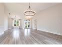 Bright living room featuring wood-look tile floors and a statement chandelier for an elegant touch at 9017 Province St, Sarasota, FL 34240