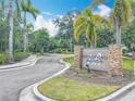 Welcome to Bradford Manor, with stone accented sign surrounded by palm trees, landscape and welcoming entrance at 1053 Grantham Dr, Sarasota, FL 34234