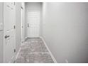Well-lit hallway features neutral paint, tile flooring, and doors, creating a clean transition in the home's design at 1053 Grantham Dr, Sarasota, FL 34234
