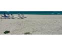 A serene beach with lounge chairs is the perfect spot for a relaxing vacation at 1100 Benjamin Franklin Dr # 802, Sarasota, FL 34236