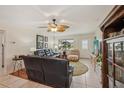 Spacious living room with tile and hardwood floors, ceiling fan, and ample seating with natural light at 1190 Jamaica Rd, Venice, FL 34293