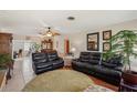 Comfortable living room featuring tile floors, ceiling fan, and multiple seating areas with a view to the dining area at 1190 Jamaica Rd, Venice, FL 34293