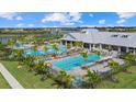 Resort-style community pool and amenity center surrounded by palm trees and lush landscaping at 16012 Sunny Day Dr, Bradenton, FL 34211