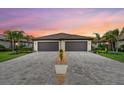 Striking symmetrical view of home with a paver driveway leading to two-car garages at 16012 Sunny Day Dr, Bradenton, FL 34211