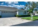 Charming home featuring a two-car garage and front yard with mature trees and lush landscaping at 1612 Fairway Oaks Dr, Palmetto, FL 34221