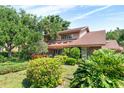 A charming house surrounded by beautiful landscaping on a sunny day with a blue sky at 1671 South Dr, Sarasota, FL 34239