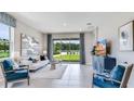 Bright living room with large windows and sliding glass doors, offering plenty of natural light at 18052 Cropside Trl, Lakewood Ranch, FL 34211
