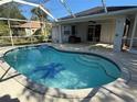 Beautiful in-ground pool with screen enclosure and a covered patio area for relaxing by the pool at 21498 Beaverton Ave, Port Charlotte, FL 33952