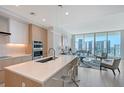 Open kitchen featuring a center island, bar seating, and modern appliances at 301 Quay Commons # 1208, Sarasota, FL 34236
