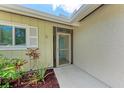 Close-up view of front door with a screen and decorative plants at 3707 Kingswood Dr, Sarasota, FL 34232