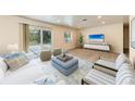 Bright living room with stylish furniture, neutral colors, and sliding doors to backyard at 3707 Kingswood Dr, Sarasota, FL 34232