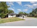 Well-maintained single-story home with a large driveway, lush lawn and mature trees at 3921 Marlborough Pl, Sarasota, FL 34241