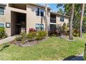 Attractive condo building showcasing covered entries and surrounding lush landscaping with palm trees at 4061 Crockers Lake Blvd # 27, Sarasota, FL 34238