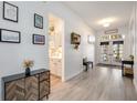 Bright foyer featuring wood-look floors, elegant lighting, and views into the kitchen at 4307 Manfield Dr, Venice, FL 34293