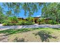 Beautiful one story home with a well-maintained lawn, mature trees, and lush landscaping at 4647 Stone Ridge Trl, Sarasota, FL 34232