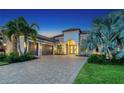Beautiful home with a three-car garage and paved driveway, framed by manicured lawn and tropical landscaping at 4809 Benito Ct, Bradenton, FL 34211