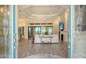 Bright living room featuring tile floors, a fireplace, tray ceilings, and sliding glass doors at 4809 Benito Ct, Bradenton, FL 34211