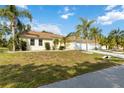 Attractive single-Gathering home boasting a manicured lawn, palm trees, and a lengthy driveway to its garages at 5266 Wagon Wheel Dr, North Port, FL 34291