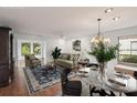 Bright, staged living room featuring hardwood floors, a chandelier, and natural light from large windows at 532 Oak Hill Cir # 12, Sarasota, FL 34232