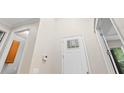 High ceiling with a bright entryway featuring wood-look floors and a white door with glass inserts at 5709 Wild Sage Cir, Sarasota, FL 34238