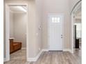 Bright entryway featuring wood-look floors, a white door, and an alcove with built-in bench seating at 5709 Wild Sage Cir, Sarasota, FL 34238