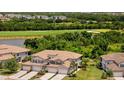 Gorgeous home with landscaping, a tile roof, and paver driveway, set against golf course and pond views at 5843 Wake Forest Run # 104, Bradenton, FL 34211