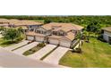 Charming paired villas featuring a tile roof, two-car garage, paver driveway, and verdant landscaping at 5843 Wake Forest Run # 104, Bradenton, FL 34211