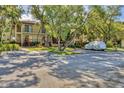 Condo building exterior surrounded by mature trees and ample parking at 6501 Mourning Dove Dr # 215, Bradenton, FL 34210