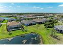Aerial view of neighborhood with many screened pools backing to a large pond at 7136 Summerland Cv, Bradenton, FL 34202