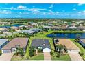Aerial view of a neighborhood featuring beautiful homes and serene ponds on a sunny day at 7136 Summerland Cv, Bradenton, FL 34202
