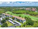 Stunning aerial view of condo community with golf course, lush landscaping, and ample parking spaces at 8755 Olde Hickory Ave # 7107, Sarasota, FL 34238