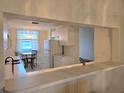 Kitchen featuring a pass-through bar with a dining area in the background at 8755 Olde Hickory Ave # 7107, Sarasota, FL 34238