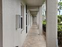 View of a covered exterior walkway with tile flooring and white walls at 8755 Olde Hickory Ave # 7107, Sarasota, FL 34238