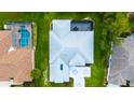Overhead view showing the home's layout, roof, and adjacent pool in the neighboring property at 8979 Grey Oaks Ave, Sarasota, FL 34238