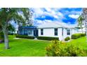 Lush green backyard featuring well-maintained lawn and manicured shrubs, offering a serene outdoor space at 8979 Grey Oaks Ave, Sarasota, FL 34238