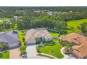 Expansive aerial view of a home with manicured lawns, mature trees, and a serene lake nearby at 9016 30Th E St, Parrish, FL 34219