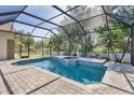 Inviting screened-in pool area with a spa, tiled decking, and lush greenery at 9016 30Th E St, Parrish, FL 34219