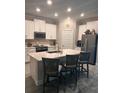 Modern kitchen featuring a large island with seating, stainless steel appliances, and sleek white cabinetry at 9808 Campanula Ct, Land O Lakes, FL 34637