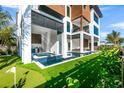 Inviting backyard featuring a sparkling pool, jacuzzi, outdoor kitchen, and putting green at 100 6Th S St, Bradenton Beach, FL 34217