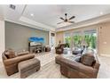 Spacious living room with wood-look tile, ceiling fan, and large sliding doors leading to outdoor patio at 1219 Thornbury Dr, Parrish, FL 34219