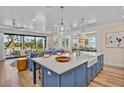 Gourmet kitchen with a large island, prep sink, marble countertops, and an open floor plan at 135 Avenida Veneccia, Sarasota, FL 34242