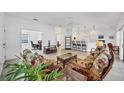Bright living room with tile floors, a ceiling fan, and patio doors leading to the screened-in patio at 1516 Red Oak Ln, Port Charlotte, FL 33948