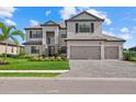 Charming two-story home featuring a three-car garage, attractive landscaping, and a paved driveway at 15315 Golden Beam Pl, Bradenton, FL 34211