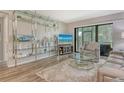 A cozy living room featuring modern décor, light wood floors, and a view of the outdoors through a sliding glass door at 2055 Gulf Of Mexico Dr # G2-108, Longboat Key, FL 34228