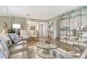 A combined living and dining area with contemporary furnishings, light wood floors, and a glass dining table set at 2055 Gulf Of Mexico Dr # G2-108, Longboat Key, FL 34228