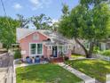 Charming pink home with a well-manicured lawn, white picket fence and inviting front porch seating area at 2330 7Th W Ave, Bradenton, FL 34205