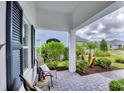Inviting front porch features cozy seating and meticulous landscaping at 2631 Sapphire Blue Ln, Bradenton, FL 34211
