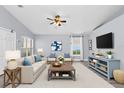 Bright, staged living room with a ceiling fan, large windows, and modern decor throughout at 3429 97Th E Ln, Palmetto, FL 34221