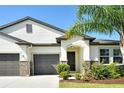 Close-up of a lovely single-story home showcasing the front entrance, landscaping, and stone accents at 364 Grande Vista Blvd, Bradenton, FL 34212